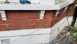 Masonry beaming using helical bar around bay window